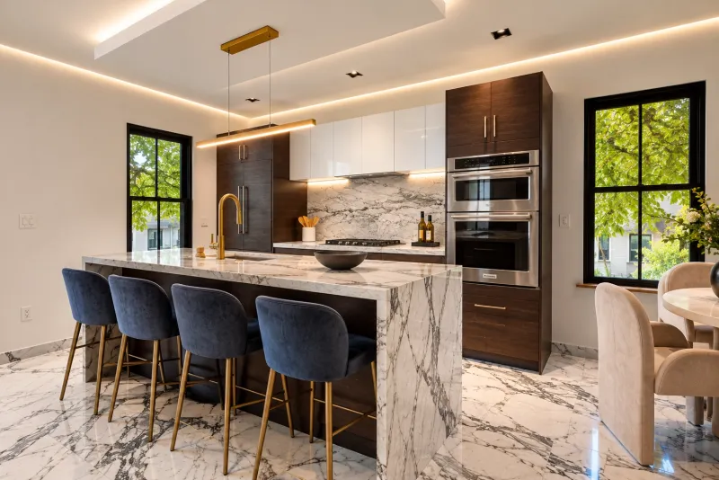 Walnut kitchen with velvet stools and double ovens